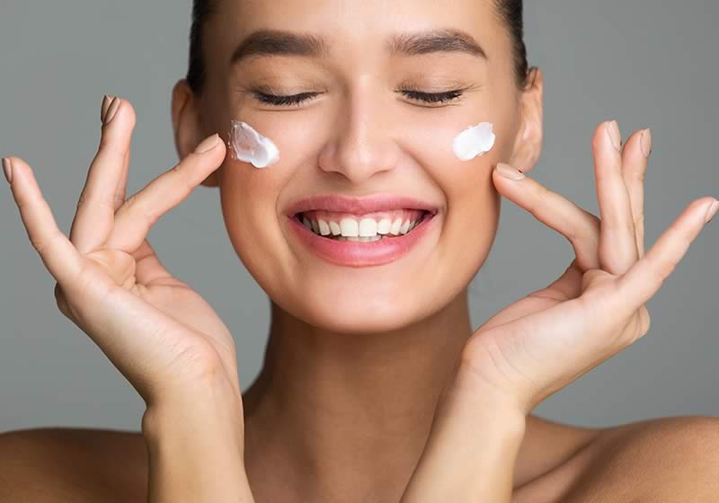 Woman applying skincare product to her face