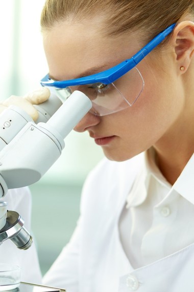 Female scientist looking through microscope in laboratory
